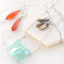 Boucles d'oreilles et colliers avec des pierres naturelles en forme de goutte et du quartz 